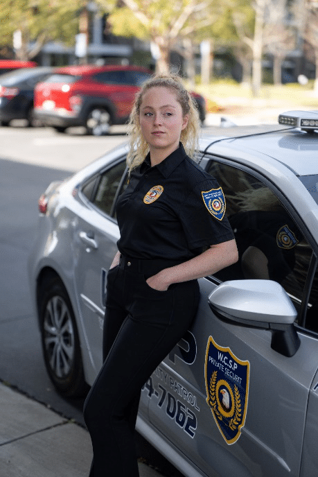 An image of a security guard standing against a car