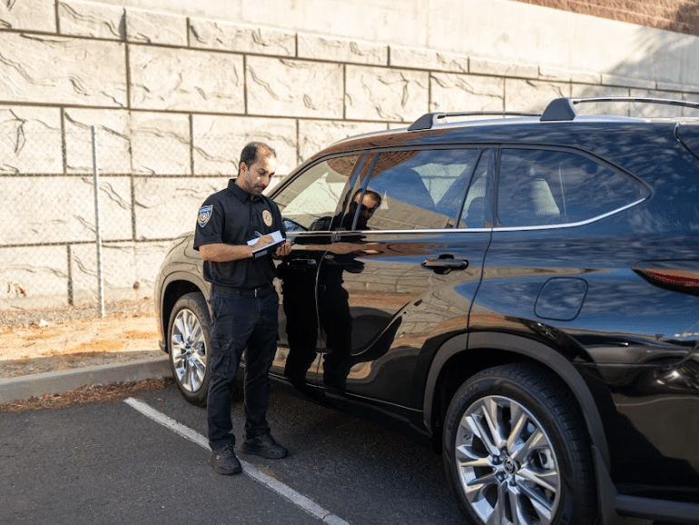 Guard checking a vehicle near a building