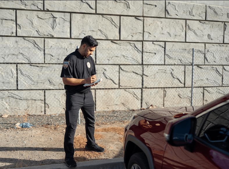 Security guard reviewing a visitor badge at a plant entrance